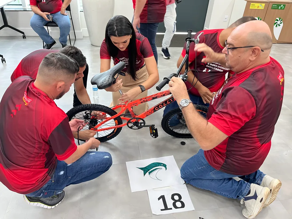 Participantes colaborando na montagem de uma bicicleta