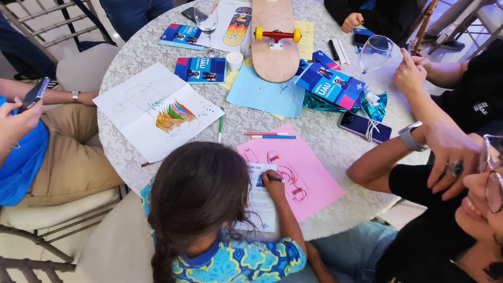 Participantes criando desenhos para personalizar os skates