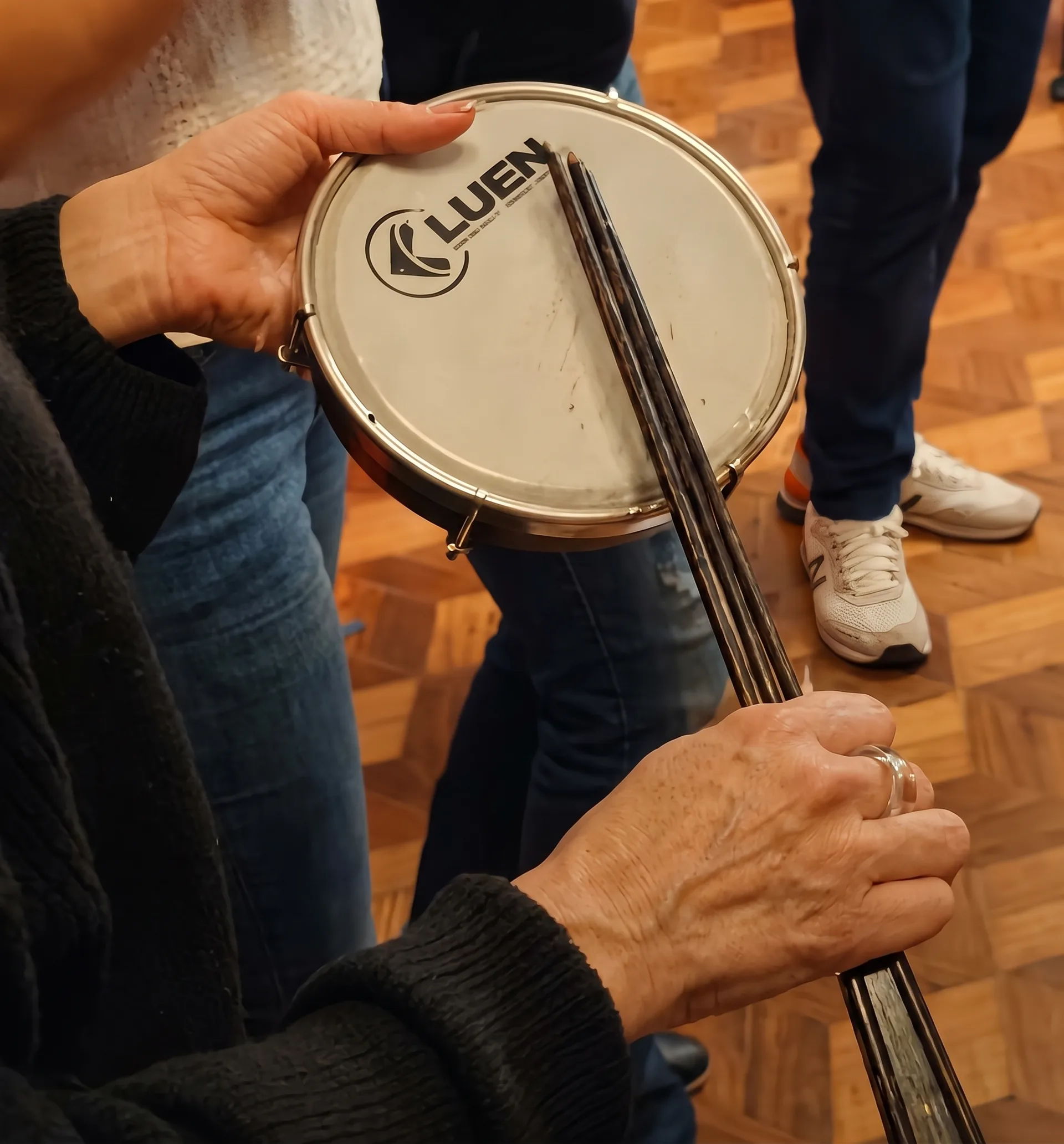 Detalhe de um tamborim e baquetas na experiência Team Music