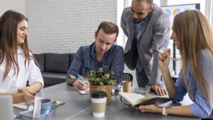 Profissionais em reunião colaborativa analisando ideias e estratégias em equipe, representando um ambiente de trabalho alinhado à cultura ágil.