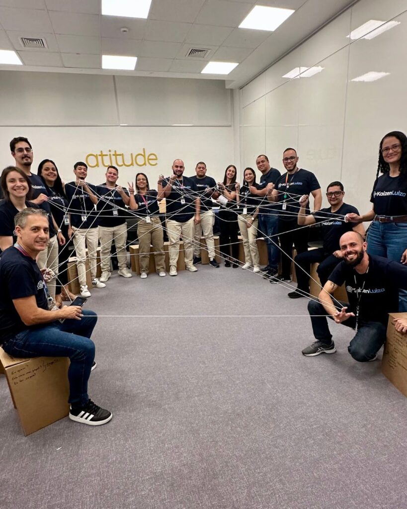 Equipe participando de uma dinâmica de integração com fios de barbante, simbolizando conexões e trabalho em equipe. A ação faz parte de uma iniciativa de desenvolvimento de profissionais promovida pela Magazine Luiza em parceria com a Aldeia Incompany.