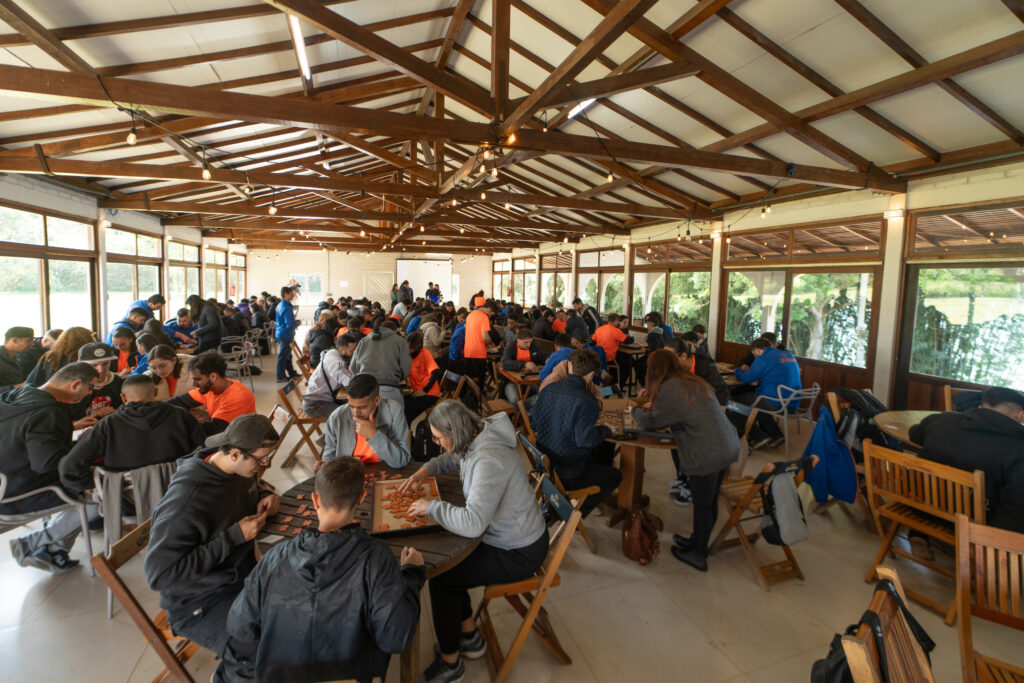 Grande grupo de colaboradores da JR Adamver reunidos em dinâmica coletiva, promovendo colaboração no ambiente de trabalho.