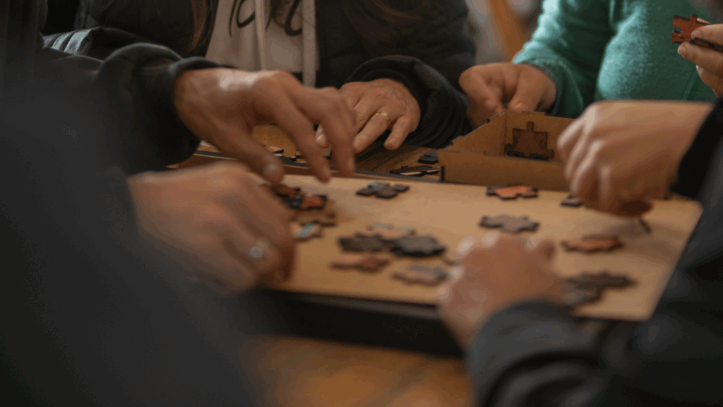 Equipe participando de uma atividade de team building, unindo esforços para montar um quebra-cabeça durante o "Construindo Puzzle" da Aldeia Incompany, focado em colaboração e adaptabilidade.