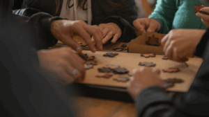 Equipe participando de uma atividade de team building, unindo esforços para montar um quebra-cabeça durante o "Construindo Puzzle" da Aldeia Incompany, focado em colaboração e adaptabilidade.