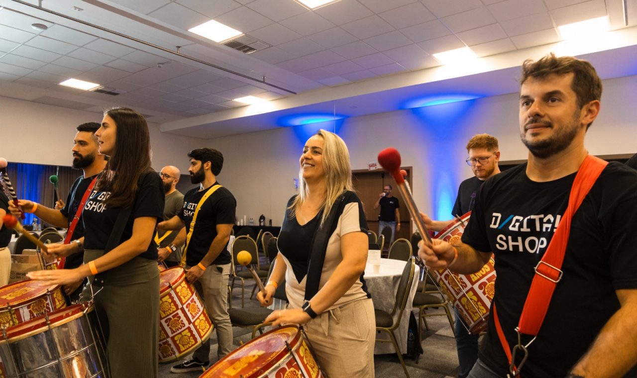 Participantes do Team Building Music, tocando instrumentos musicais em uma dinâmica de trabalho em equipe